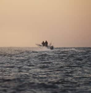 Offshore fishing boat cruising in the Pacific Ocean at sunset