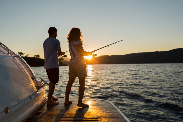 Fishing from a boat at sunset.