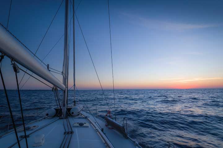 Cruising sailboat at sunset.
