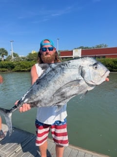 Fisherman holding African Pompano on dock after Florida fishing trip