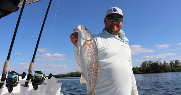 Capt. Matt Luttman of Inshore Action Charters in St. Petersburg, Florida, holding a redfish on his boat