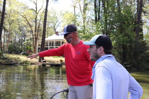 Fishing guide pointing out where an angler should cast their line