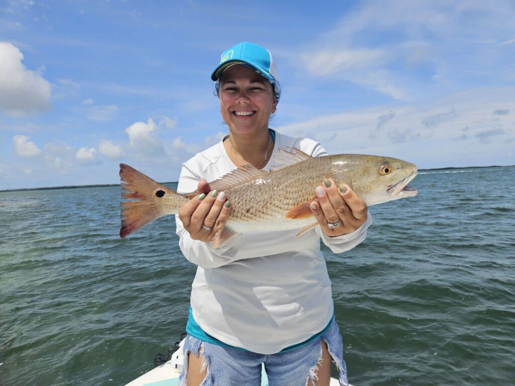 Fishing charter customer holding a redfish caught with Capt. Angelo Gentile near Clearwater, Florida