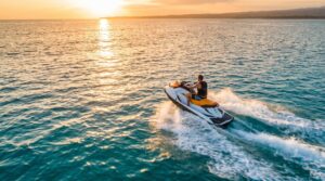 Person riding a jet ski on turquoise ocean water at golden hour