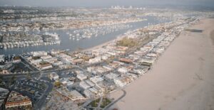 Aerial cityscape showcasing a coastal area with marina and sandy beach.