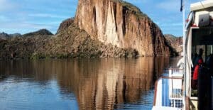 A scenic view of Canyon Lake with a boat cruise and stunning rock formations in Apache Junction, Arizona.