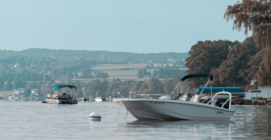 Peaceful scene of boats on Skaneateles Lake, New York, with a serene landscape backdrop.