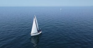 Aerial view of sailboats navigating the calm waters of Lake Michigan on a clear summer day.