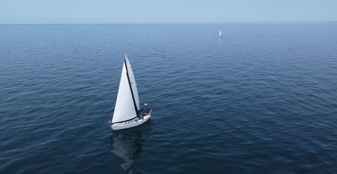 Aerial view of sailboats navigating the calm waters of Lake Michigan on a clear summer day.