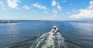 A boat cruises through Corpus Christi Bay under a bright summer sky, exuding freedom and adventure.