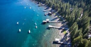 Stunning aerial shot of Lake Tahoe's forested shoreline and boats during summer.