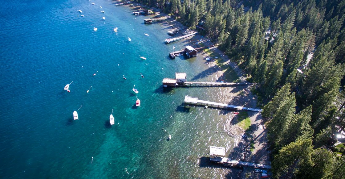 Stunning aerial shot of Lake Tahoe's forested shoreline and boats during summer.